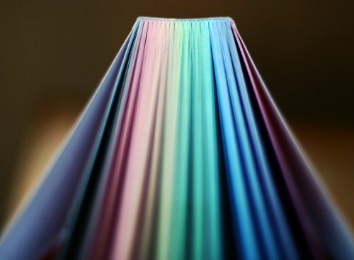 book with rainbow paged fanned out in soft light